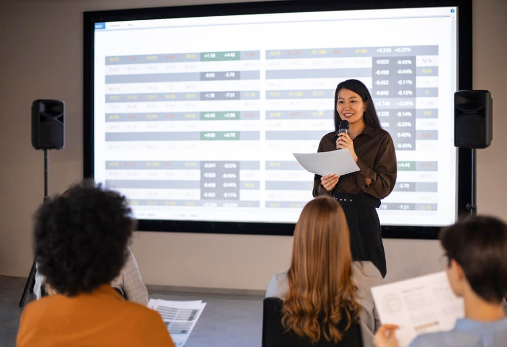 women with mic and notes presenting