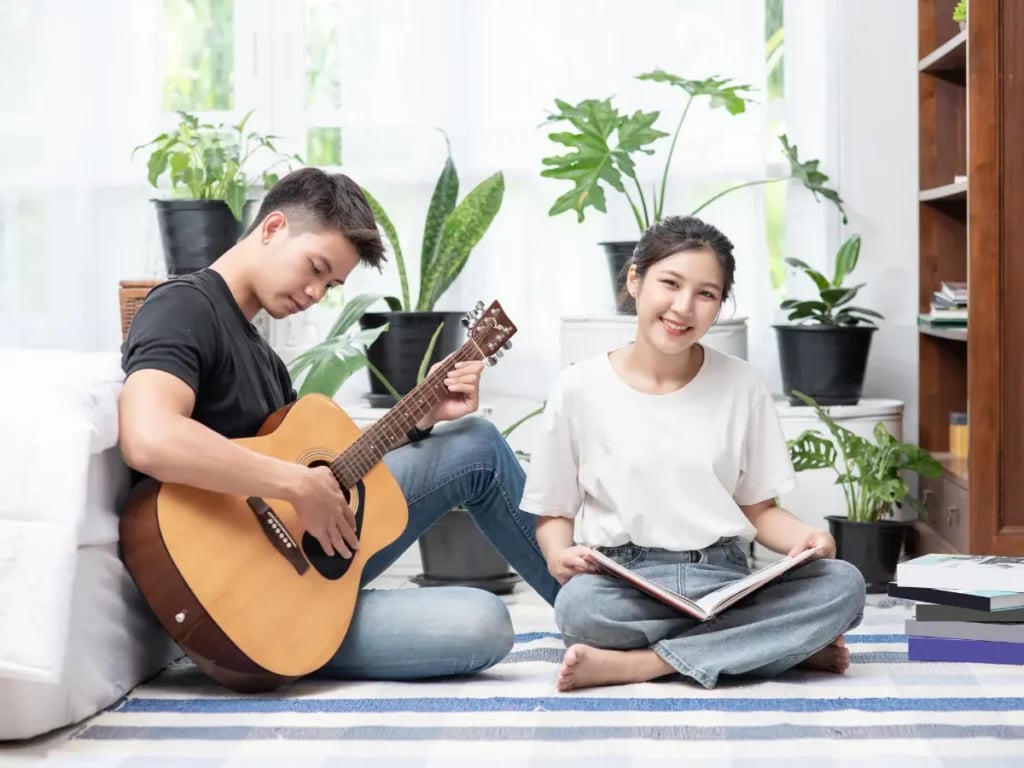 a man playing guitar in front of girl